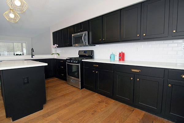 Black Shaker Cabinetry Geometric Gold Pendants Subway Tile Backsplash