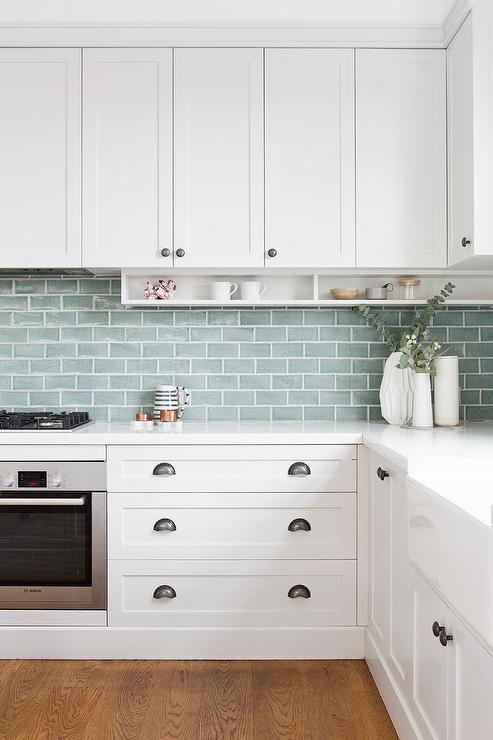 Dark Cup Pulls on White Shaker Cabinets with Seafoam Green Backsplash