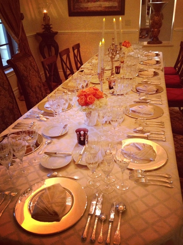Dining Table with Orange Rose Centerpiece and Layered Gold Chargers