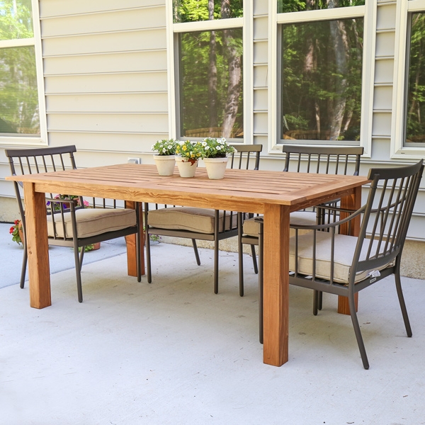 Dining Table with Spindle Back Metal Chairs and Slatted Wood Top on Patio