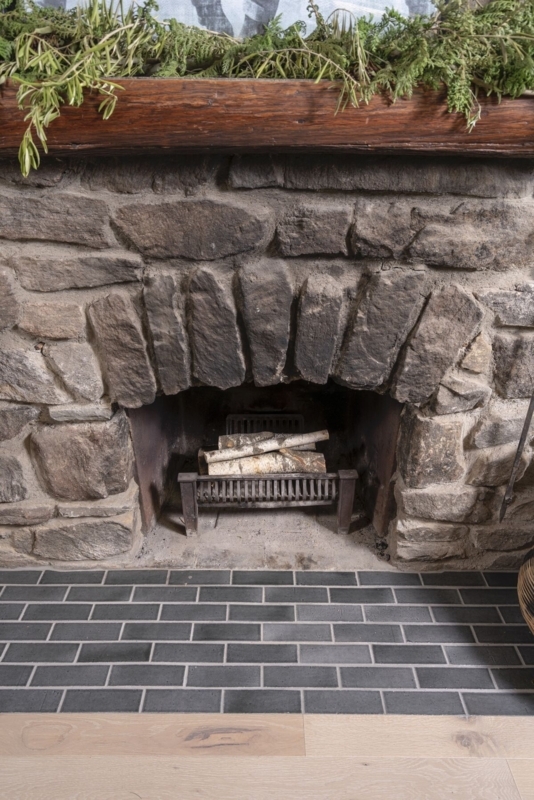 Fireplace: Rustic Stone Surround with Matte Charcoal Brick Hearth