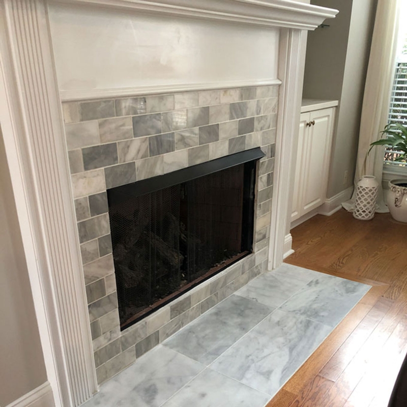Fireplace: Traditional Fluted White Mantel with Marble Subway Tile