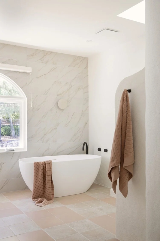 Soaking Tub with Marble Wall Tiles and Checkered Floor Pattern