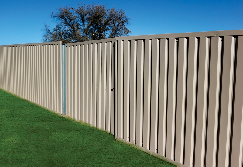Tan Metal Privacy Fence featuring Ribbed Surface Design