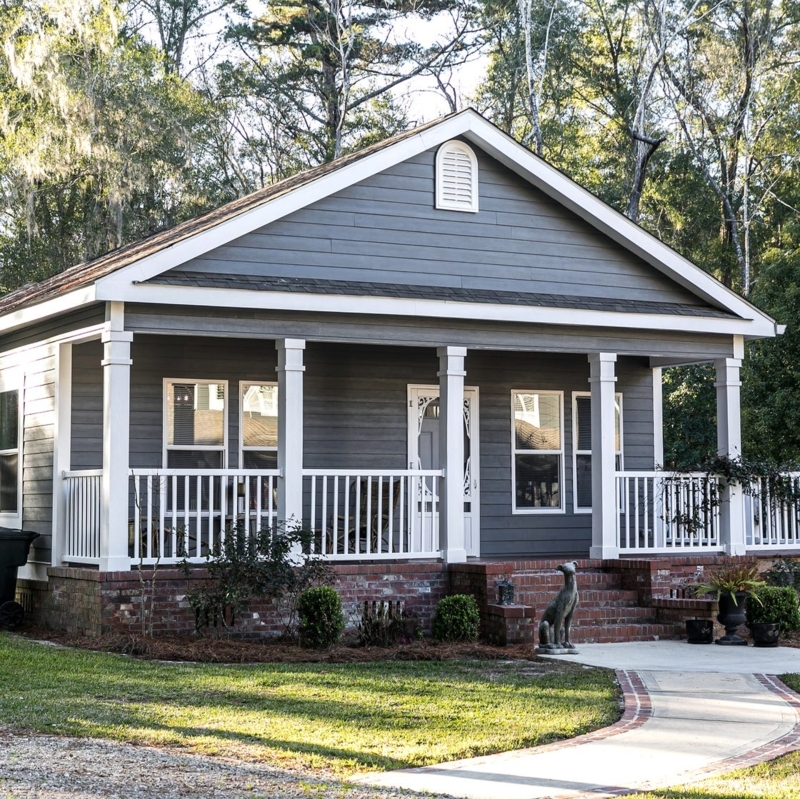 Blue Gray Cottage Exterior with White Railings and Brick Foundation