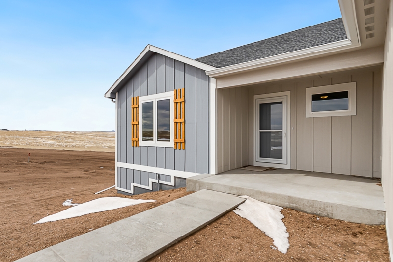 Blue Grey Board and Batten Siding with Wood Toned Shutters