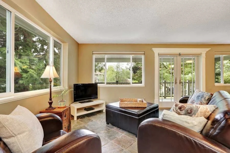 Bright Living Room with Leather-Like Chairs and Wrap-Around Windows