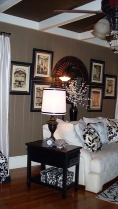 Brown Paneled Wall Living Room: Ornate Gallery & White Sofa Decor