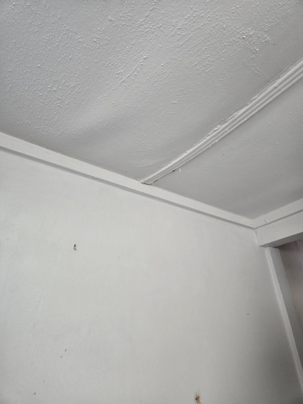 Ceiling: White Textured Panel Sag with Visible Trim Separation