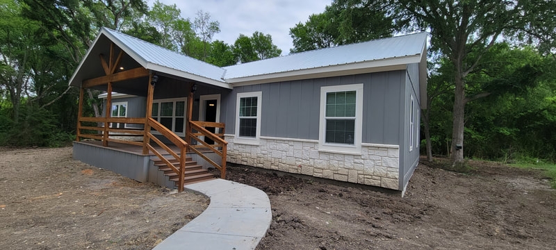 Charcoal Modular Home with Stone Wainscoting and Exposed Wood Trusses