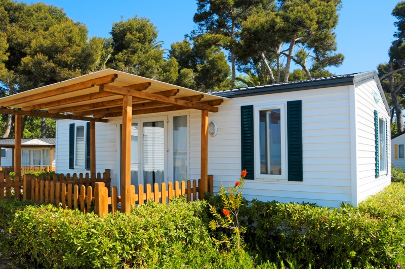Coastal Cottage Mobile Home: Wooden Pergola & Dark Green Shutters