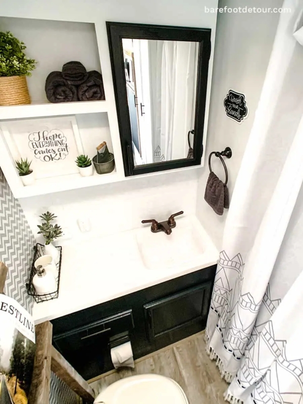 Compact RV Bathroom with Recessed Wall Shelving and Chevron Pattern