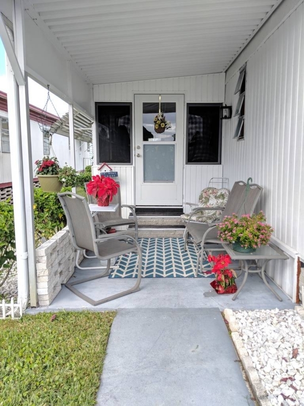Covered Porch Entryway with Blue Chevron Rug and Red Floral Accents