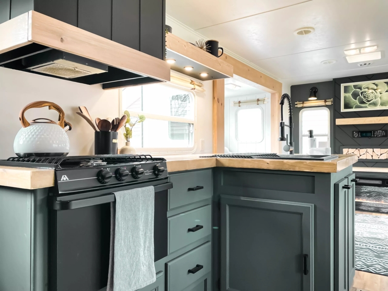 Dark Green RV Kitchen Cabinets with Butcher Block & Black Fixtures