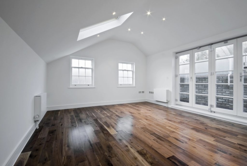 Dark Wood Flooring Attic Room with Sloped Ceiling and Skylight