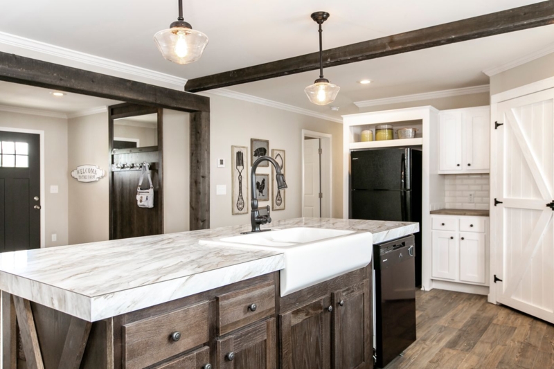 Dark Wood Island with Marble Top in Farmhouse Kitchen with Barn Door.