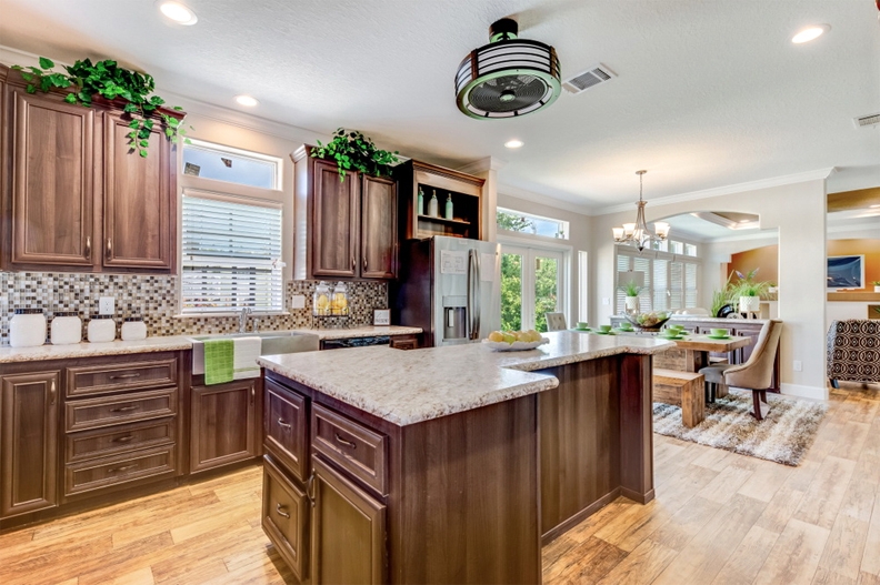 Dark Wood Raised Panel Cabinets with Island and Mosaic Backsplash