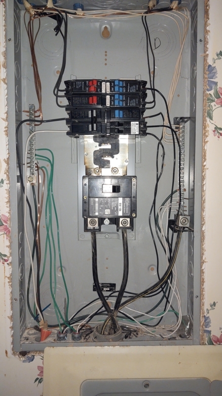 Electrical Panel with 200 Amp Main Breaker set against Floral Wallpaper