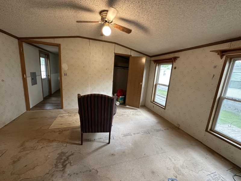 Exposed Subfloor Before Flooring Installation with Striped Accent Chair