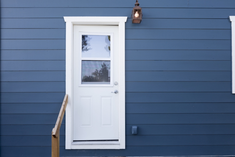Exterior Door in Half Lite Style against Navy Blue Siding Contrast