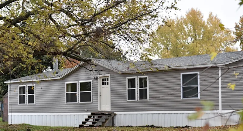 Farmhouse Manufactured Home with Grey Siding and Vertical Skirting