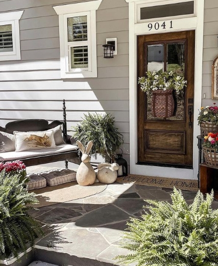 Flagstone Patio Entryway Ideas with Wood Stained Door and Garden Decor