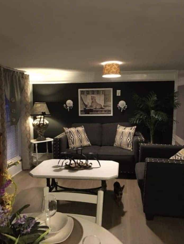 Glam Living Room with Black Accent Wall and Nailhead Trim Seating