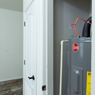 Grey Water Heater with Black Hardware in Modern Utility Room Layout