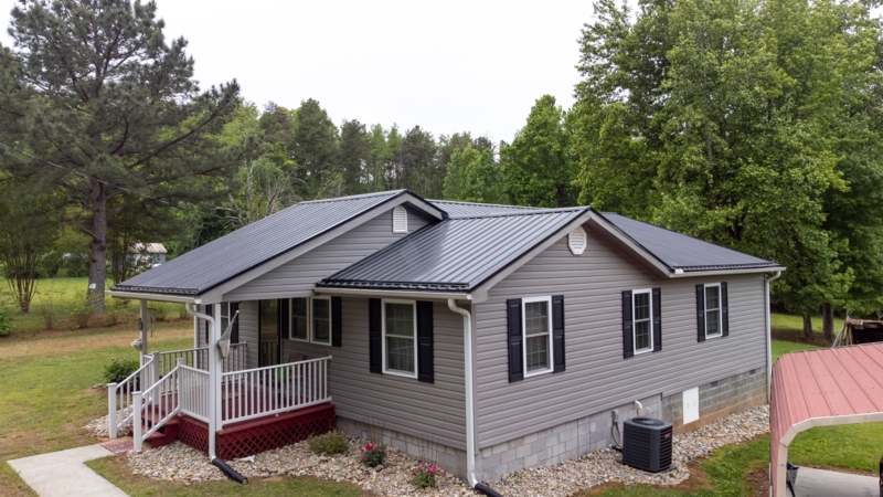 House Charcoal Metal Roof Siding Combination and River Rock Landscaping