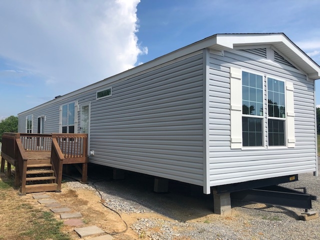 Light Blue Manufactured Home Exterior with Integrated Wooden Deck