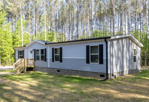 Manufactured Home Black Gutters on Gray Siding in Wooded Setting