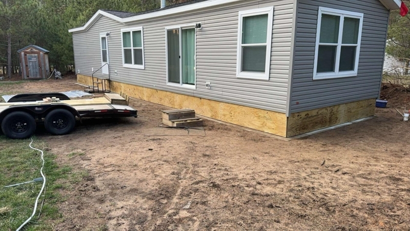Manufactured Home Exterior with Grey Vinyl Siding and Plywood Skirting