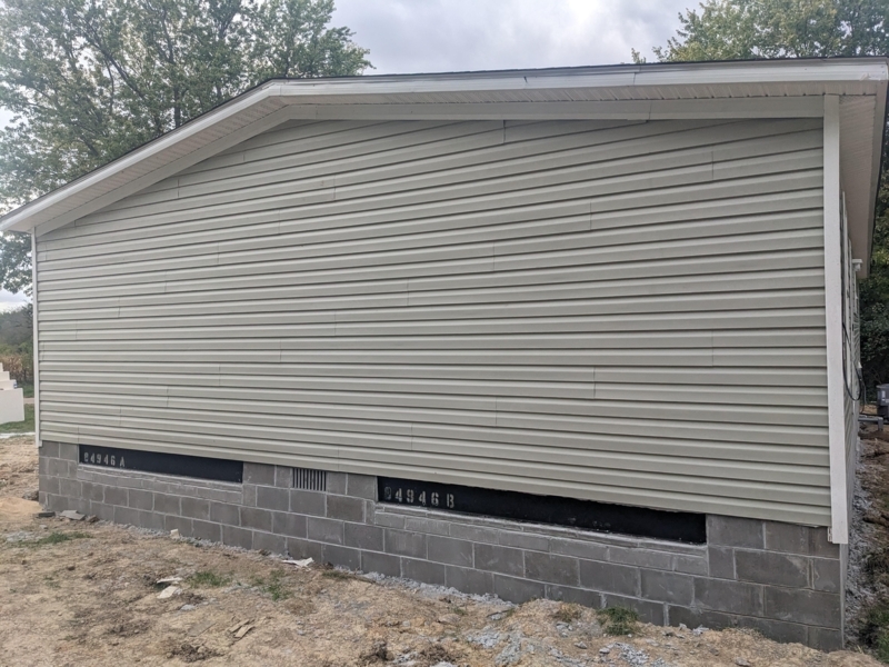 Manufactured Home: Sage Green Lap Siding & Concrete Base.