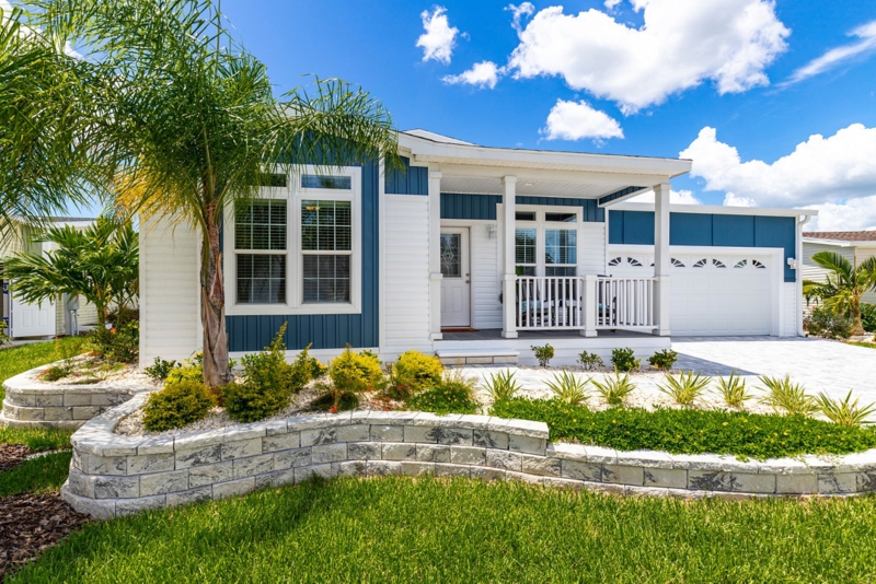 Manufactured Home with Blue and White Facade and Tiered Stone Planters