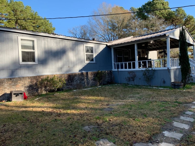Manufactured Home with Covered Porch, Brick Skirting, and Stepping Stones