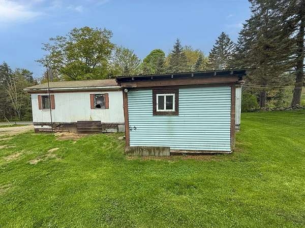 Manufactured Home with Dual Structures and Wooded Backdrop