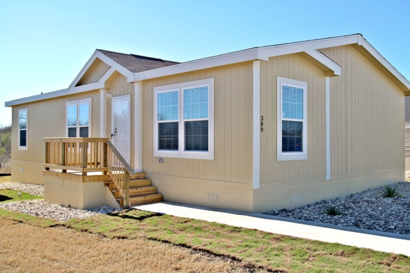 Manufactured Home with Yellow Siding and Wooden Porch Entry