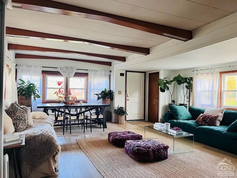 Mid-Century Living Room with Exposed Beams and Green Velvet Sofa