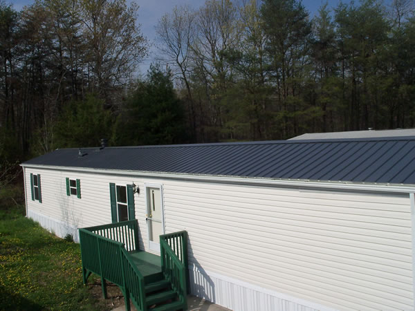 Mobile Home Charcoal Grey Metal Roofing Upgrade With Green Deck Accents