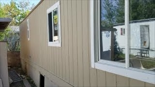 Mobile Home Exterior: Modernized Tan Vertical Siding.