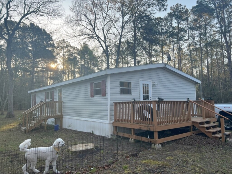 Mobile Home Exterior: White Vertical Skirting & Large Wooden Deck