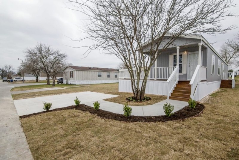 Mobile Home Exterior with Curved Walkway and White Vinyl Siding