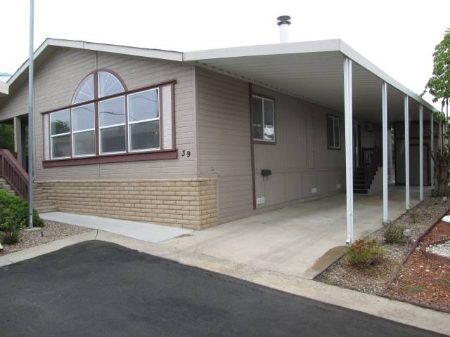 Mobile Home Faux Rock Skirting with Arched Window Facade and Carport