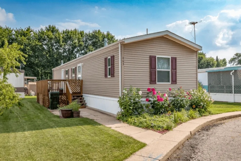 Mobile Home with Maroon Shutters and Wooden Side Deck Curb Appeal