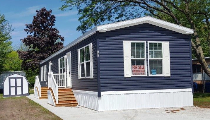 Mobile Home with Navy Blue Siding and Wooden Entry Stairs