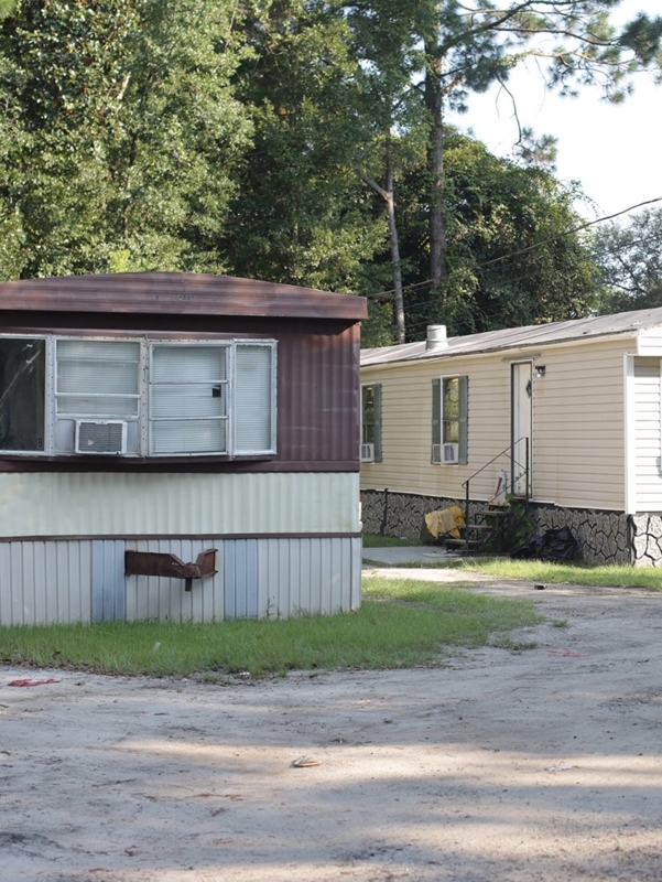 Mobile Home with Window AC Unit and Faux-Stone Skirting