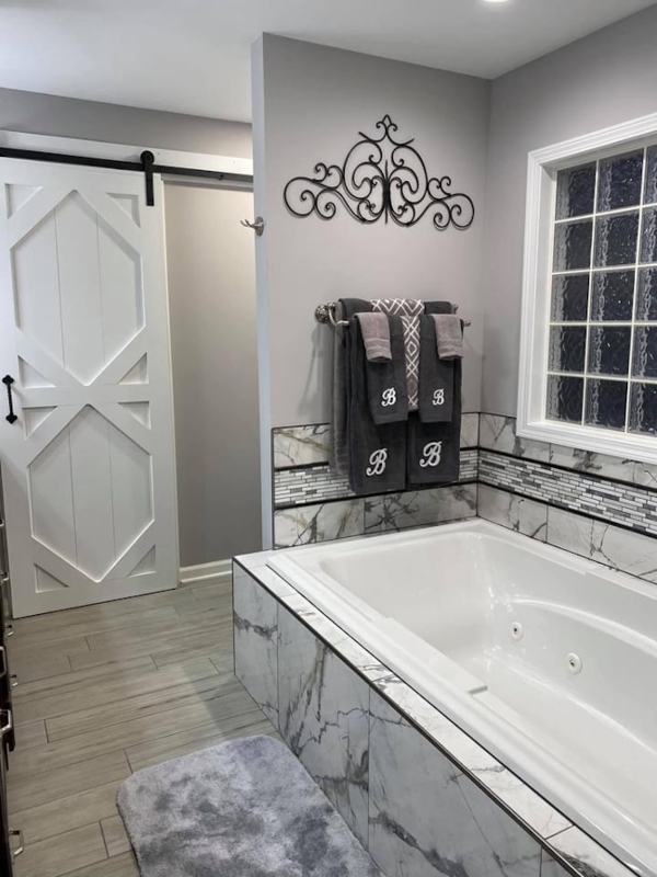 Modern Farmhouse Master Bath with Geometric Barn Door and Marble-Look Tile