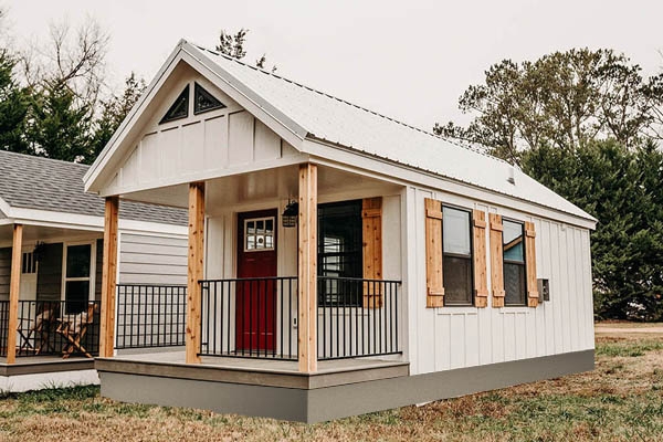 Modern Farmhouse Modular Cabin with Red Door and Wood Shutters
