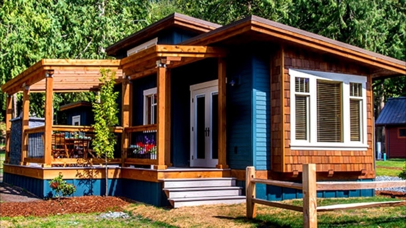 Modern Tiny Home Exterior with Navy Siding and Wraparound Pergola Deck