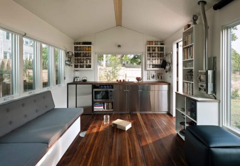 Modern Tiny Home with Stainless Steel Cabinets and Built-In Seating
